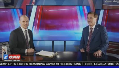 OAN correspondent Pearson Sharp and MyPillow CEO Mike Lindell sitting at an unbranded news desk, waiting after an interview
